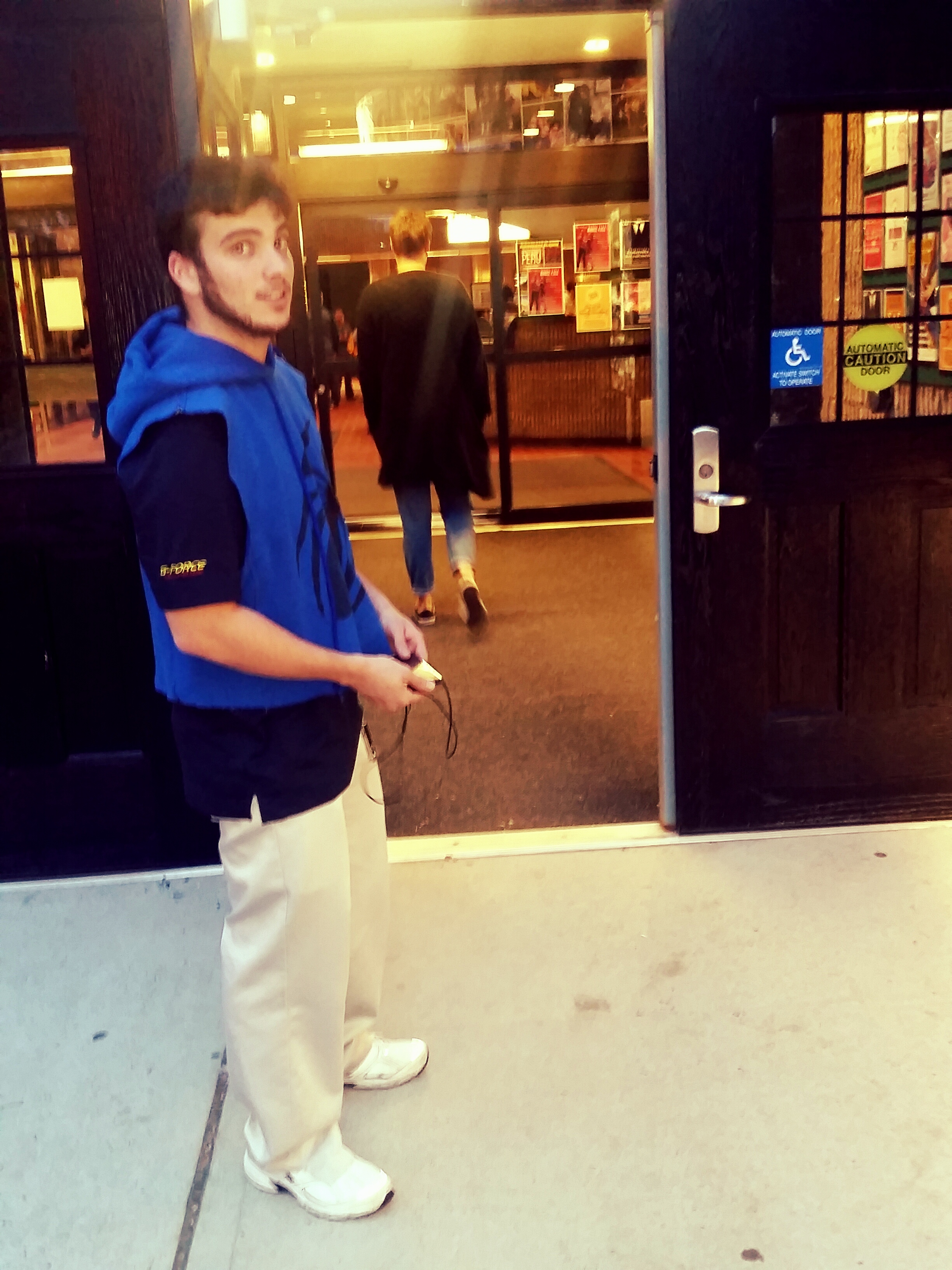 A student holding the door open for oncomers walking into Hillwood Commons. By Kristen Linsalata